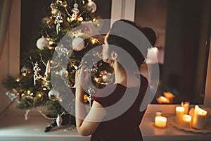 Woman in red dress over christmas tree background