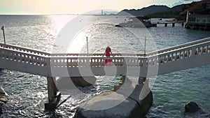 Woman in Red Dress Stands on White Bridge Panorama