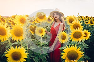Woman with red dress in sunflower field