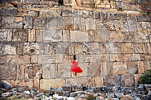 Woman in a red dress walks through Pamukkale, Turkey. Beautiful view of the sights