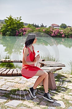 Woman in a red dress walks through Pamukkale, Turkey. Beautiful view of the sights
