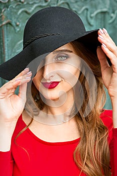 Woman in red dress wearing black hat