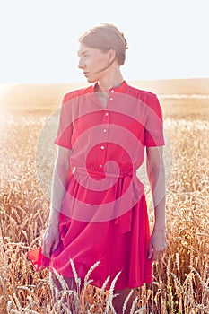 Woman in red dress in yellow wheat field