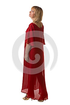 Woman in red elegance dress standing back and looking at side.