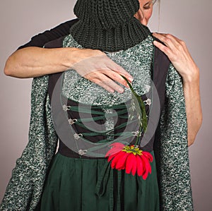 A woman with a red flower in her hand hugging other woman. photo