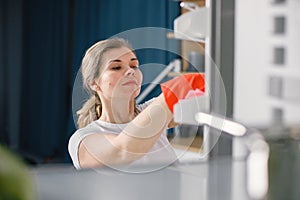 Woman in red gloves is doing cleaning and wash a refrigerator inside