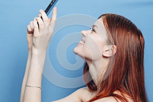 woman with red hair bare shoulders talking on the phone