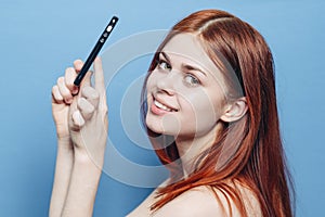 woman with red hair bare shoulders talking on the phone