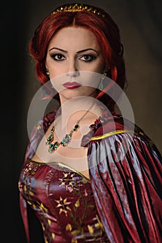 Woman with red hair in elegant royal garb photo