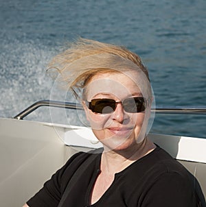 Woman with red hair enjoys the wind of the speed boat