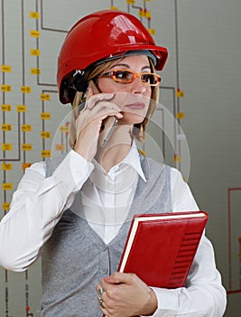 Woman with red helmet make call in power distribution control center