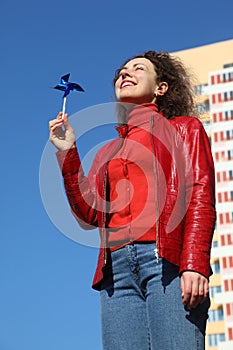 Woman in red jacket and jeans playing with spinner