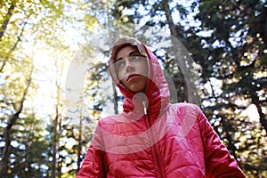 Woman in a red jacket walks in the autumn forest