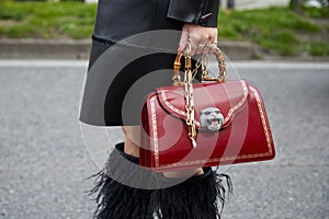 Woman with red leather bag with tiger head with gems and bamboo handle before Alberta Ferretti fashion show,