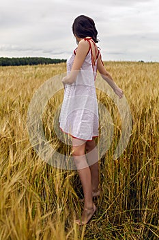 Woman in a red light dress stands in a field