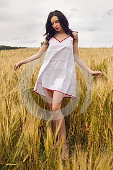 Woman in a red light dress stands in a field