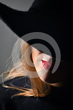 A Woman With Red Lips In A Black Hat