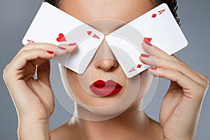 Woman with red lips is holding two aces in her hands