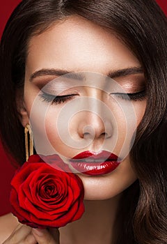 Woman Red Lips with Rose Flower. Beauty Model Face Makeup with Closed Eyes. Fashion Brunette Girl Close up Portrait over Red