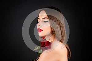 Woman with red lips and rose flower on black isolated background. Fashion beauty portrait on studio background.