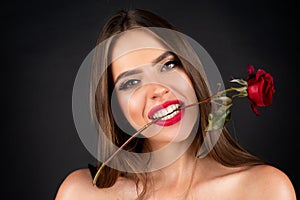 Woman with red lips and rose flower. Rose flowers in a mouth. Fashion beauty portrait on studio background. Seductive