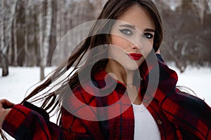 Woman with red lips in winter forest