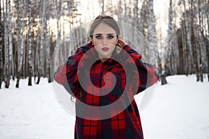 Woman with red lips in winter forest