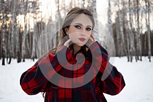 Woman with red lips in winter forest