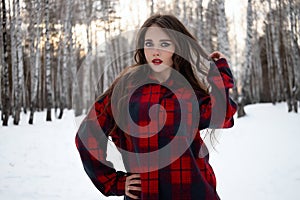 Woman with red lips in winter forest