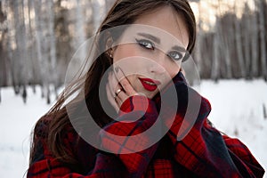 Woman with red lips in winter forest