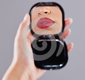 Woman, red lipstick and hand mirror for beauty application or mouth reflection, cosmetics or grey background. Person