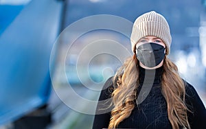 Woman with red long hair, blue eyes, young with FFP2 mask, wearing beige cap and black sweater, head portraits