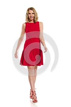 Woman In Red Mini Dress And High Heels Is Walking Towards Camera