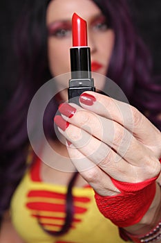 Woman with red nails holding red lipstick