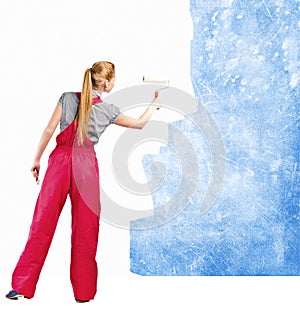 Woman in red overalls paints the soiled wall