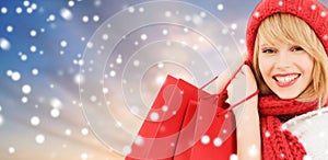 Woman with red shopping bags over snow background