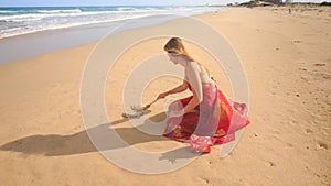 Woman in Red Squats Draws Word Love on Beach Wet Sand