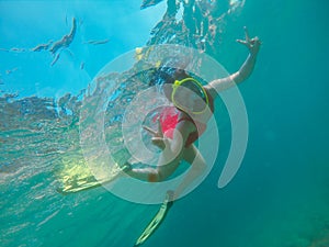 woman in red swimming suit underwater with snorkeling mask and flippers