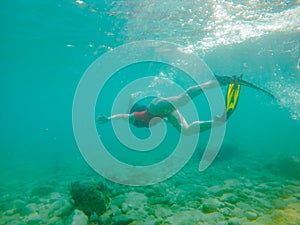 woman in red swimming suit underwater with snorkeling mask and flippers