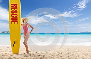 Woman in red swimsuit stand with lifeguard surf rescue board