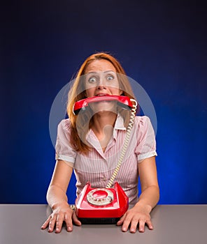 Woman with red telephone in her mouth