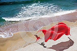 Woman with a red tissue on the beach