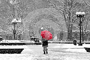 Woman with red umbrella in black and white New York City snow