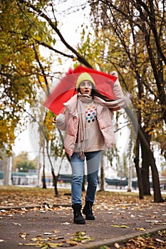 Woman with red umbrella caught in gust of wind outdoors