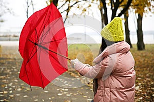 Woman with red umbrella caught in gust of wind outdoors