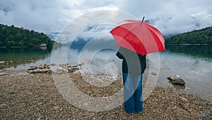 Woman with red umbrella contemplates on rain