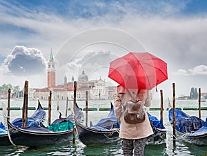 Woman with a red umbrella looking at San Giorgio Maggiore church, Venice