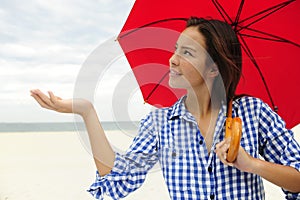 Woman with red umbrella touching the rain