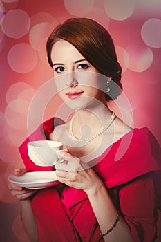 Woman in red Victorian epoch clothes with cup of tea