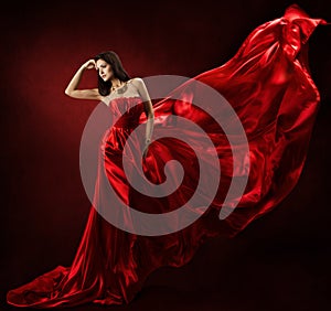 Woman in red waving dress with flying fabric